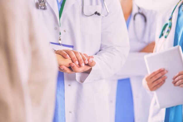 Doctors using a tablet in hospital standing in office