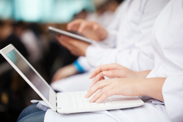 Doctors with laptop and pad on the conference