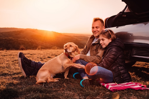 Dog giving paw to his owners at camping on the hill