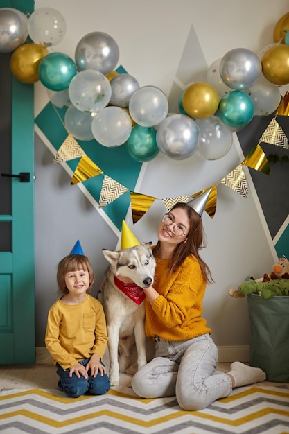 Dog pet birthday family mother and child hug their dog congratulating happy birthday