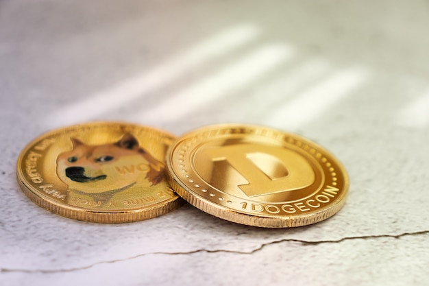 Dogecoins on a light background under the rays of the sun in close-up, gold coins, cryptocurrency