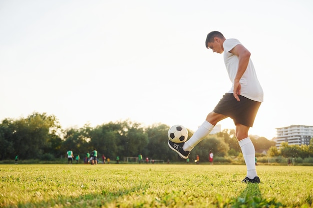 Doing different tricks Young soccer player have training on the sportive field