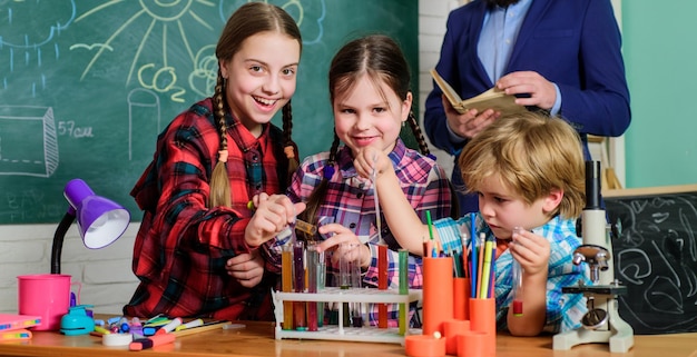 Doing experiments with liquids in chemistry lab children making science experiments Education back to school chemistry lab happy children teacher Using modern technologies