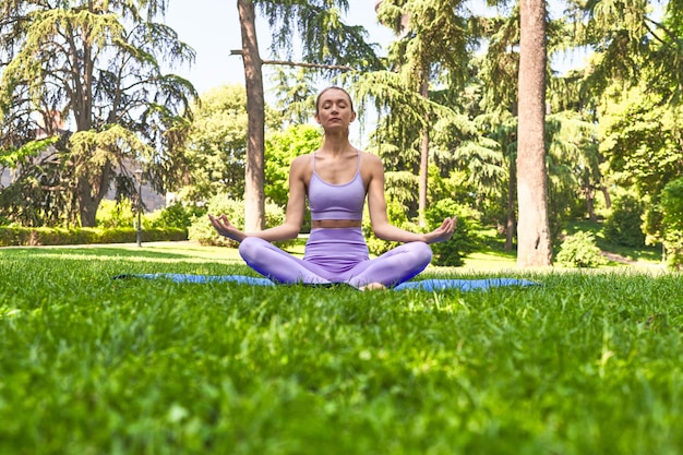 Doing yoga stretches on a mat a woman in sportswear enjoys a tranquil park morning