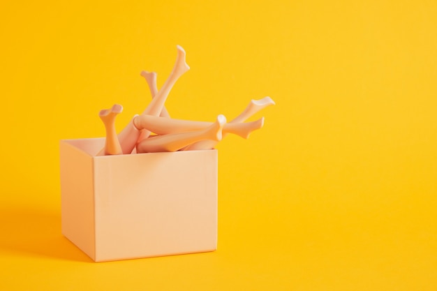 Doll legs and gift boxes on yellow background