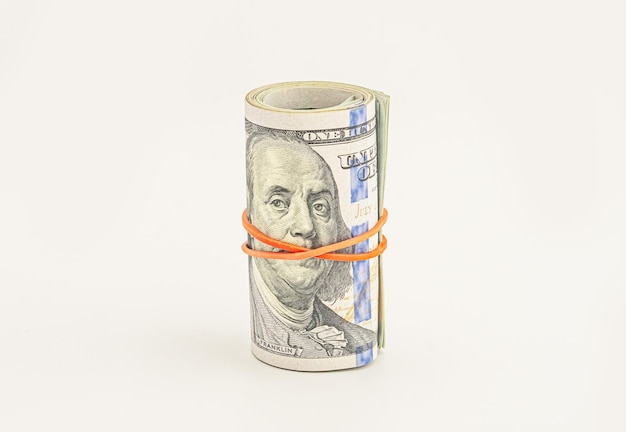 Dollar roll wrapped with red ribbon 100 dollar bills on a roll isolated on white background Rolled up money isolated on white background Dollars isolated on white background