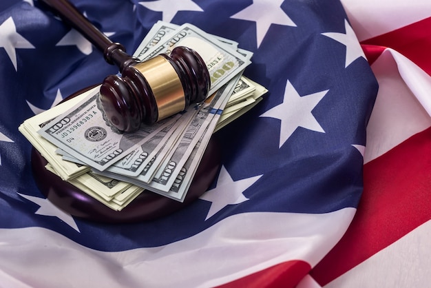 Dollars with judge's gavel on american flag