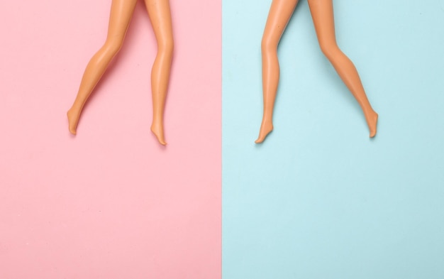 Dolls female bare feet on a bluepink pastel background Creative minimalistic layout