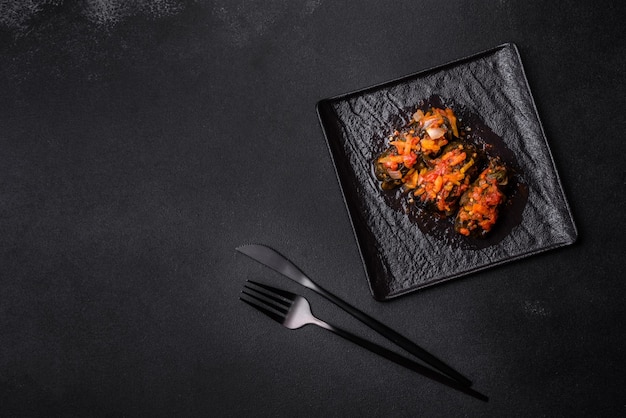 Dolma stuffed grape leaves with rice and meat on a dark background