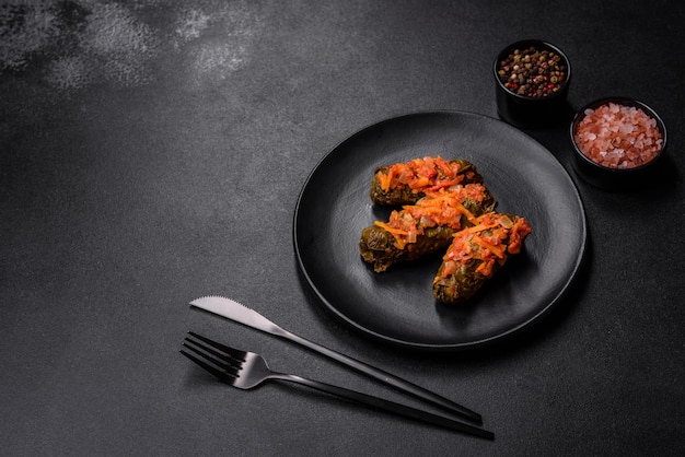 Dolma stuffed grape leaves with rice and meat on a dark background