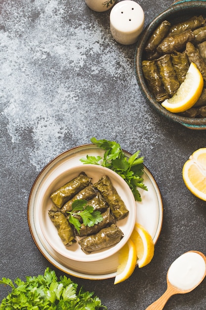 Dolma - Stuffed greek wine leaves (dolmades) on gray concrete background