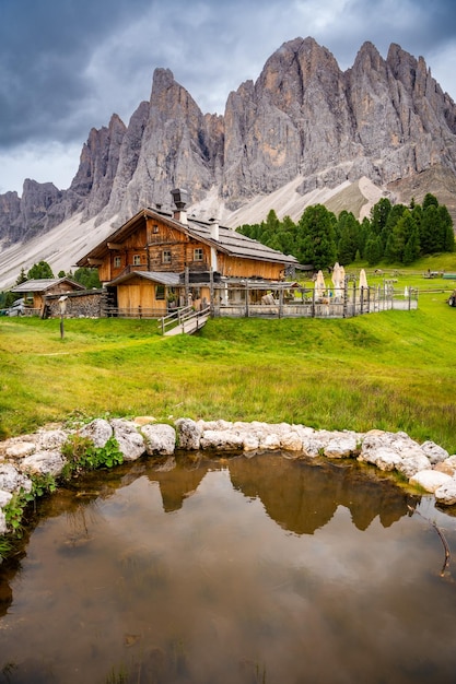 Dolomite landscape in Puez Odle Nature Park view from alpine plateau with wooden houses and green meadows