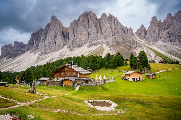 Dolomite landscape in Puez Odle Nature Park view from alpine plateau with wooden houses and green meadows