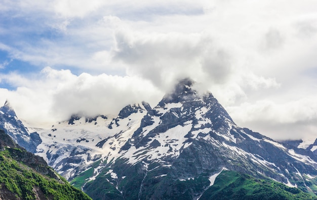 Dombay mountain range in the Caucasus in summer, snow-capped peaks and green mountain slopes