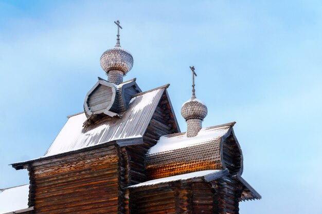 Domes with a crosses of old entirely wooden Orthodox church against the sky