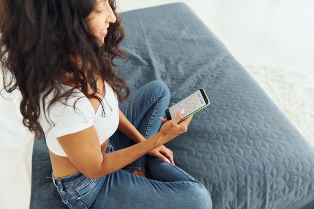 Domestic interior Cheerful woman with black curly hair is indoors