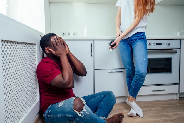 Domestic violence angry girl hitting african american man at kitchen