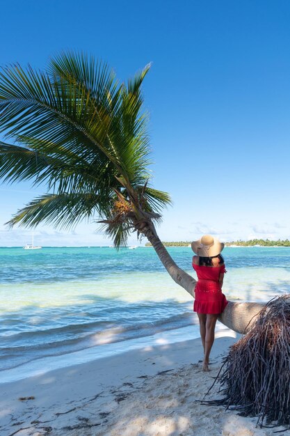 Dominican Republic of Punta Cana a girl in a hat on the ocean with turquoise water and palm trees