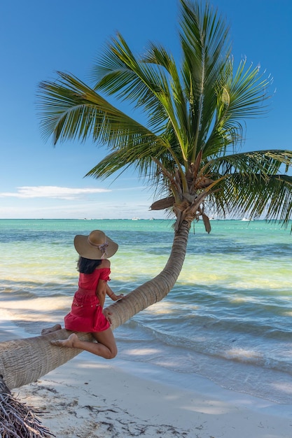 Dominican Republic of Punta Cana a girl in a hat on the ocean with turquoise water and palm trees