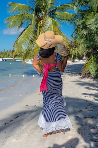 Dominican Republic of Punta Cana a girl in a hat on the ocean with turquoise water and palm trees