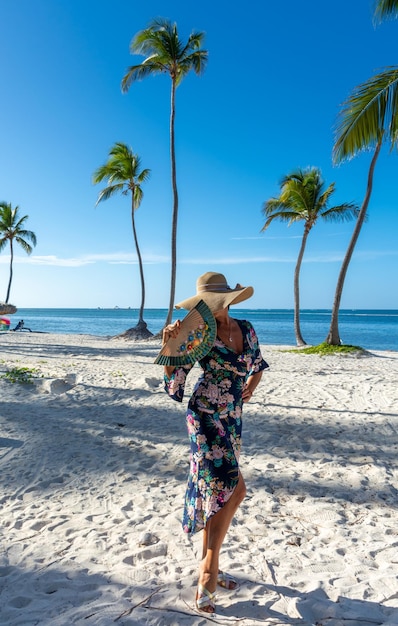 Dominican Republic of Punta Cana a girl in a hat on the ocean with turquoise water and palm trees