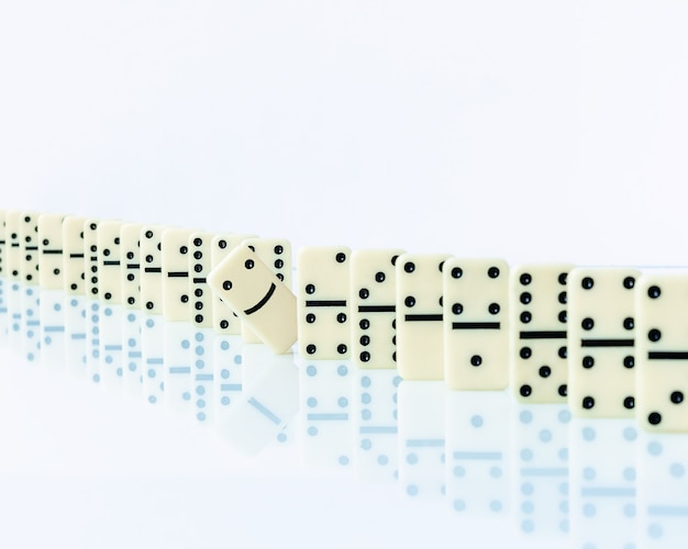 Domino piece stopping domino effect on white background