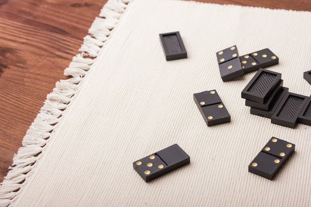 Domino pieces in black on a light table