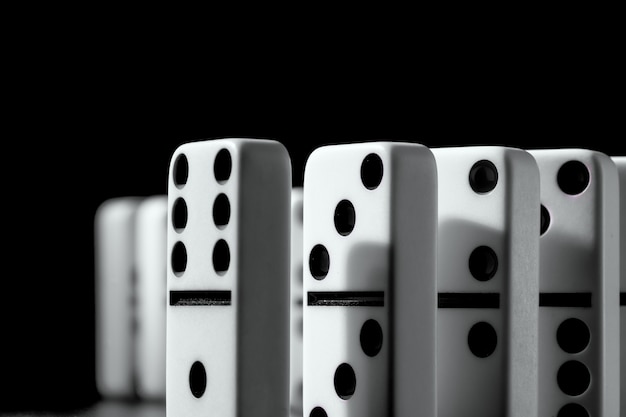 Domino pieces put in a row on black surface