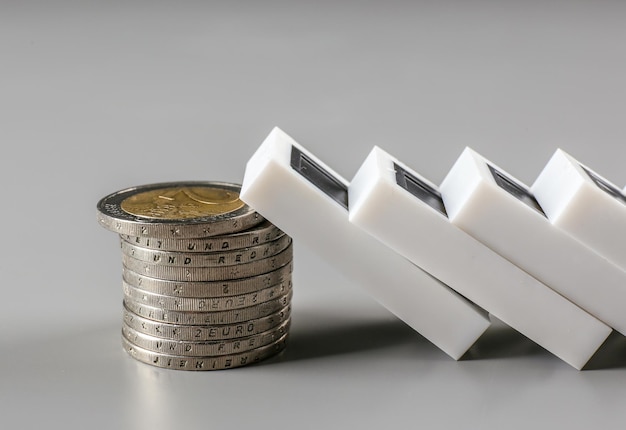 Dominoes with euro coins on grey background