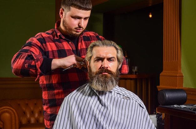 Donate hair Donation and charity concept Guy with dyed blond hair Cut hair Barber hairstyle barbershop Hipster getting haircut Sharp object near face and squirming distracts person holding it