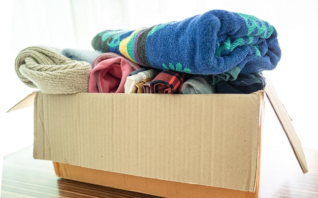 Donation box with used clothes at home to support help for poor people in the world