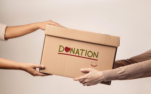 Donation Concept. The Volunteer Giving a Donate Box to the Recipient. Standing against the Walll