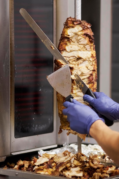 doner kebab meat. The chef prepares doner kebab. Shawarma or gyros on a metal skewer. Cooking doner