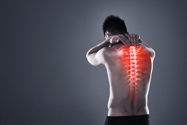 Dont take risks with a back injury Rearview shot of a young man in the studio with cgi highlighting his back injury