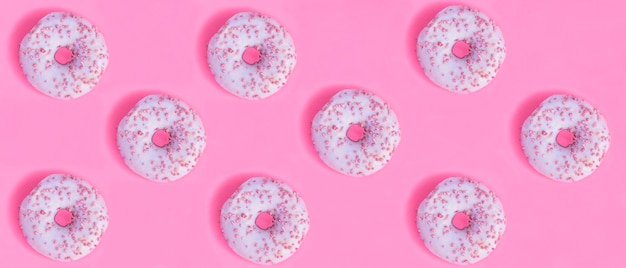 Donut with pink glaze on the pink background Banner Flat lay