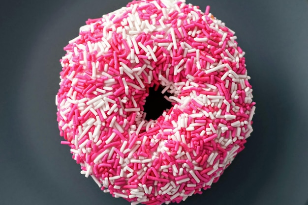 Photo a donut with pink sprinkles and sprinkles on it