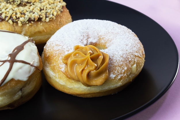 Donuts on black plate and pink background