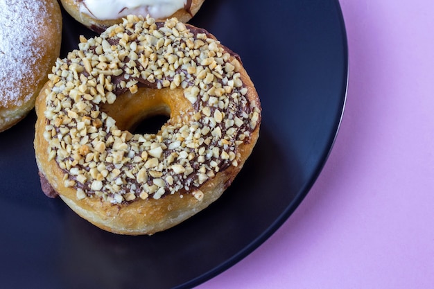 Donuts on black plate and pink background