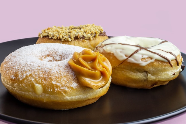 Donuts on black plate and pink background