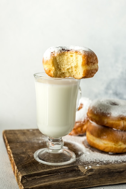 Donuts and milk lie on a wooden table