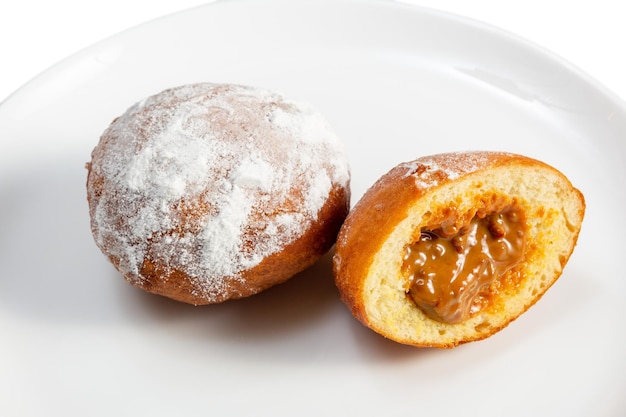 Donuts stuffed with milk caramel on a white saucer