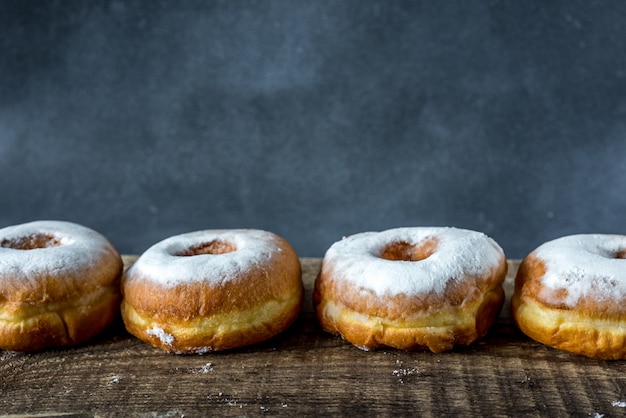 donuts with icing sugar on cement background