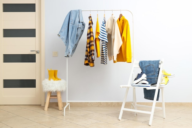 Door casual clothes on hanger chair with jeans and shoes on light background