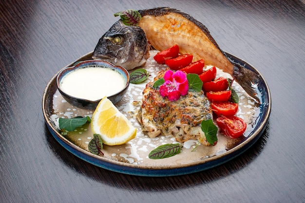 Dorado with parmesan cheese and greens On a wooden background