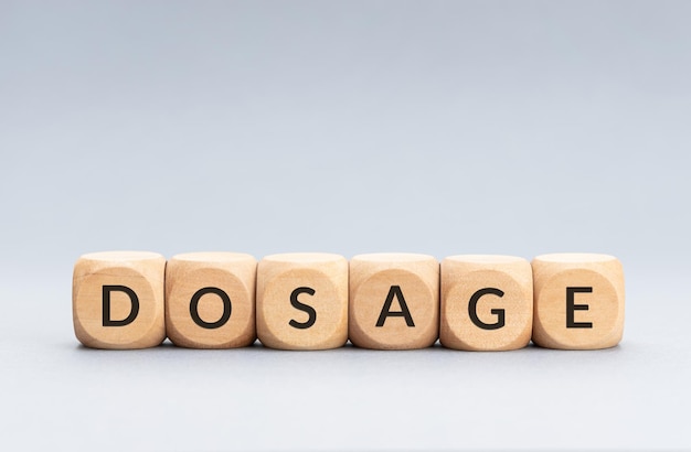 Dosage word on wooden blocks on gray background Copy space