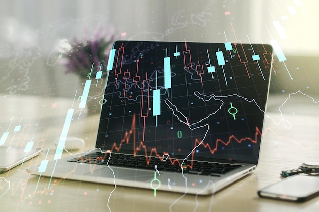 Double exposure of abstract creative financial chart with world map on laptop background research and strategy concept