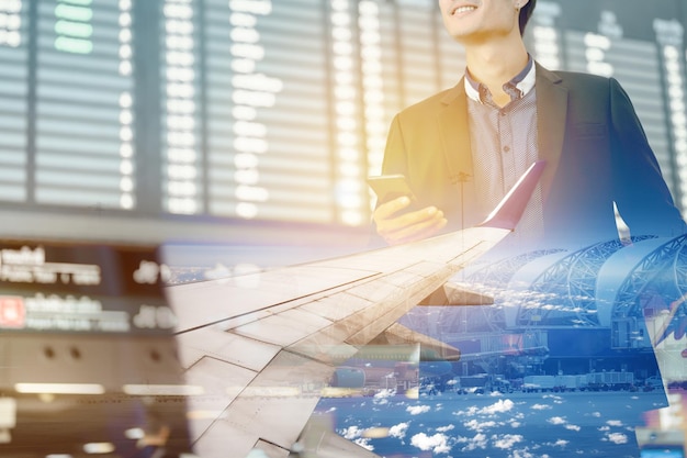 Double Exposure of airplane and businessman in terminal gate for check in boarding with luggage and phone at the airport for business trip.