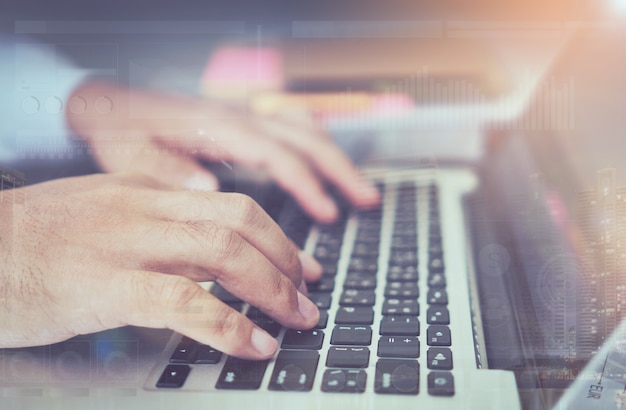 double exposure of businessman hand working laptop