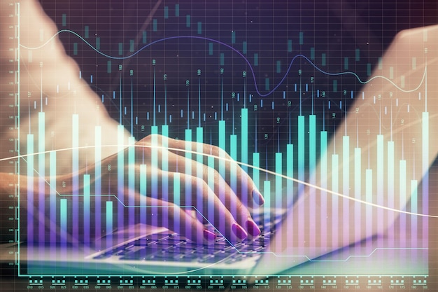 Double exposure of businesswoman hands typing on computer and forex chart hologram drawing Financial analysis concept