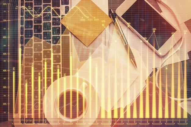 Double exposure of financial chart drawing over table background with computer Concept of research and analysis Top view